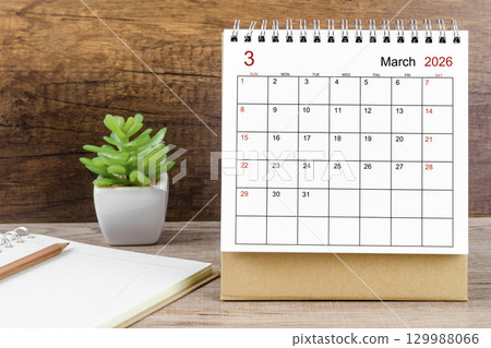 March 2026 desk calendar on the wooden worktable. 129988066