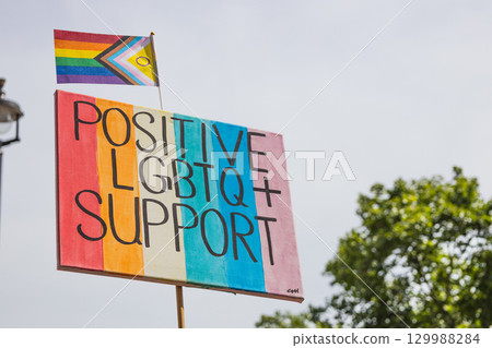 Positive LGBTQ Support sign with Progress Pride flag at inclusive street rally 129988284