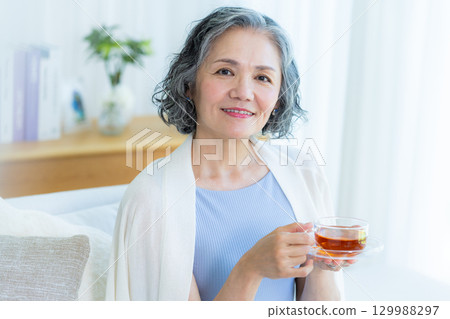 Senior woman relaxing in the living room 129988297