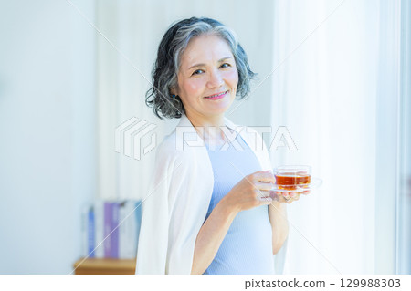 放鬆在客廳的資深婦女 129988303