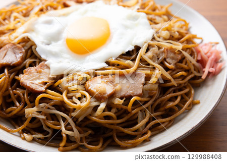 Delicious fried noodles with sauce and a fried egg 129988408