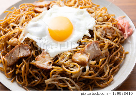 Delicious fried noodles with sauce and a fried egg Delicious fried noodles with sauce and a fried egg 129988410