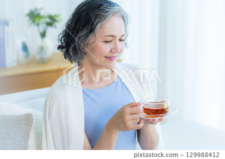 放鬆在客廳的資深婦女 放鬆在客廳的資深婦女 129988412