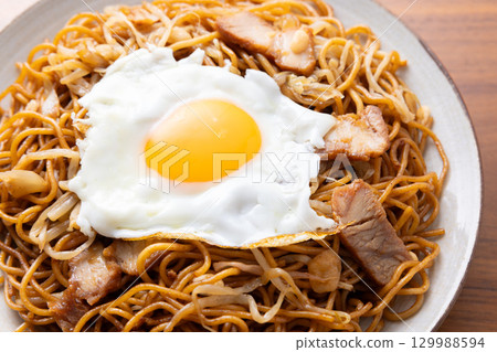 Delicious fried noodles with sauce and a fried egg 129988594