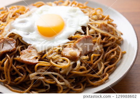 Delicious fried noodles with sauce and a fried egg 129988602