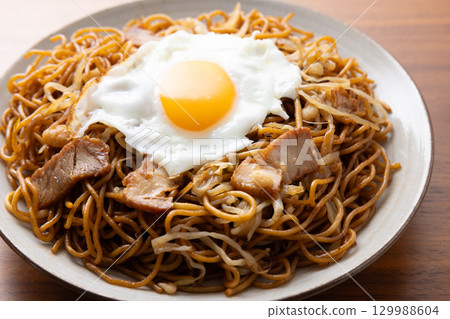 Delicious fried noodles with sauce and a fried egg 129988604