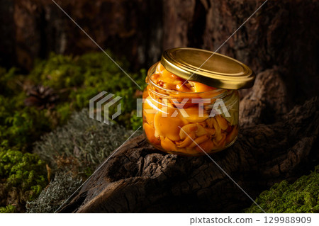 Homemade pickled honey mushrooms in a glass jar. 129988909