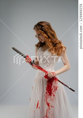 Bridal gown-clad woman wields bloodied katana, mixing beauty and violence 129989258