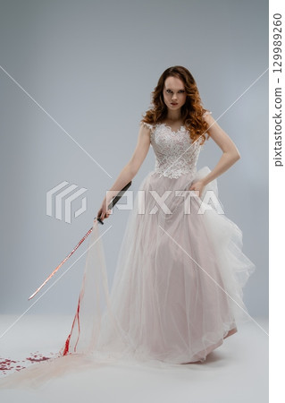 Beauty in white lace holding a katana with a hint of tragedy and mystery Beauty in white lace holding a katana with a hint of tragedy and mystery 129989260