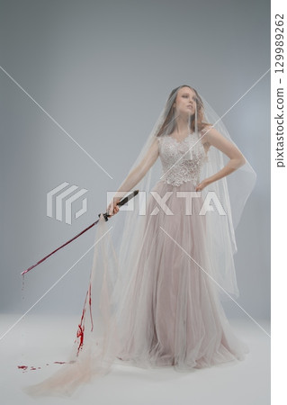 Beautiful bride in lingerie wielding katana with blood on her gown Beautiful bride in lingerie wielding katana with blood on her gown 129989262