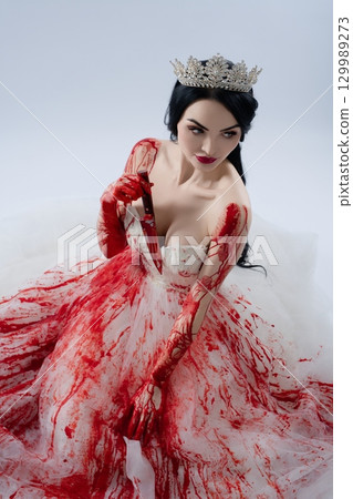 Bride in bloody lingerie holding knife while dressed as a princess 129989273