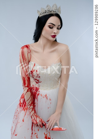 Bride in bloodied lingerie holding a knife in a hauntingly beautiful pose Bride in bloodied lingerie holding a knife in a hauntingly beautiful pose 129989286