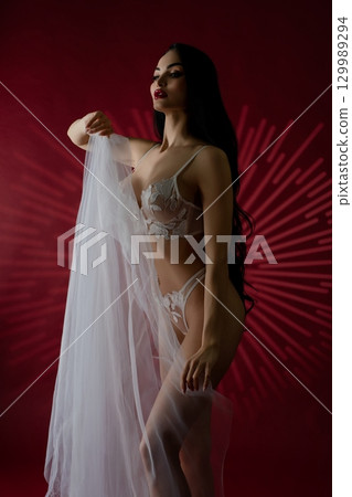 Elegance of a bridal beauty in luxurious lingerie against a bold backdrop Elegance of a bridal beauty in luxurious lingerie against a bold backdrop 129989294