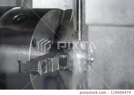 The 5-axis CNC milling machine cutting the automotive parts with liquid coolant method. 129989479