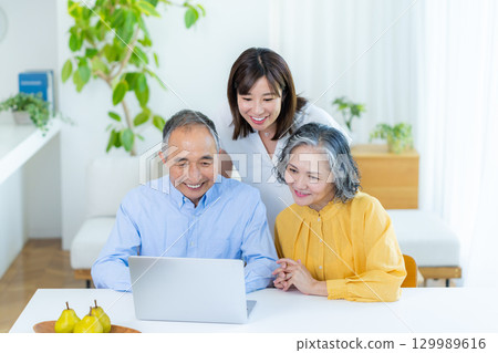 親子在客廳裡看個人電腦 129989616