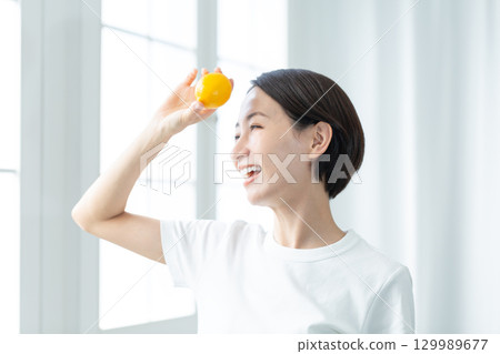 A transparent woman holding a lemon and showing a fresh smile, upper body A transparent woman holding a lemon and showing a fresh smile, upper body 129989677