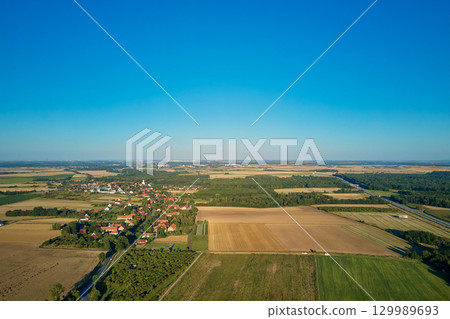 Village near farmland aerial view 129989693