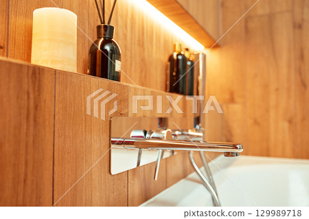 Modern chrome faucet and shower in wooden style bathroom interior Modern chrome faucet and shower in wooden style bathroom interior 129989718