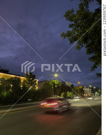 City at Night Urban Landscape of Cars Streaking Through the Evening with a Dramatic Sky 129989767