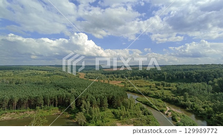 Lush Green Forest Landscape with a Winding River Under a Cloudy Sky, Natural Beauty Lush Green Forest Landscape with a Winding River Under a Cloudy Sky, Natural Beauty 129989772
