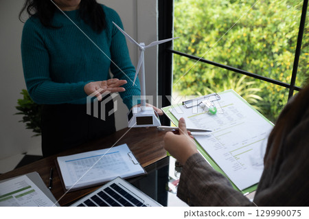 A sales representative presenting solar and wind power, alternative energy, clean energy for future. A sales representative presenting solar and wind power, alternative energy, clean energy for future. 129990075