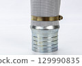 Metal pipe connector with brass strap industrial hose fitting silver and gold color close up isolated on white background durable secure plumbing equipment mechanical component 129990835