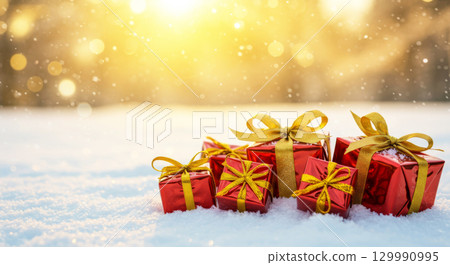Red Christmas gifts with golden ribbons in a snowy landscape with magical bokeh lights. Red Christmas gifts with golden ribbons in a snowy landscape with magical bokeh lights. 129990995