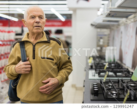 elderly man choosing gas stove in showroom of electrical appliance store elderly man choosing gas stove in showroom of electrical appliance store 129991247