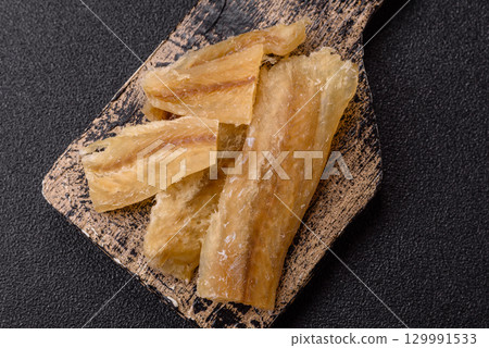 Dried salted fish, snacks or jerky, slices of white fish fillets Dried salted fish, snacks or jerky, slices of white fish fillets 129991533