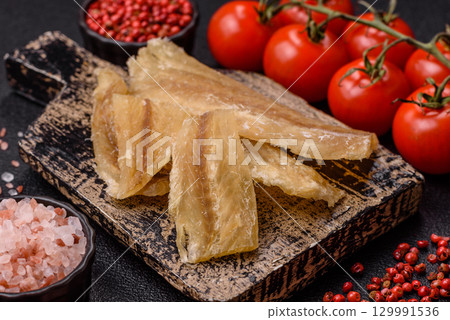 Dried salted fish, snacks or jerky, slices of white fish fillets Dried salted fish, snacks or jerky, slices of white fish fillets 129991536