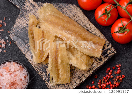 Dried salted fish, snacks or jerky, slices of white fish fillets 129991537