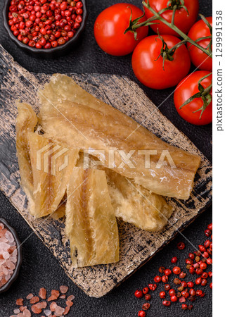 Dried salted fish, snacks or jerky, slices of white fish fillets Dried salted fish, snacks or jerky, slices of white fish fillets 129991538