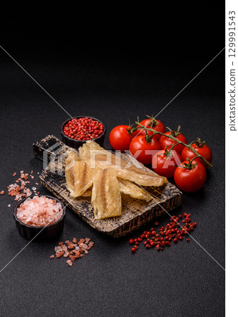 Dried salted fish, snacks or jerky, slices of white fish fillets 129991543