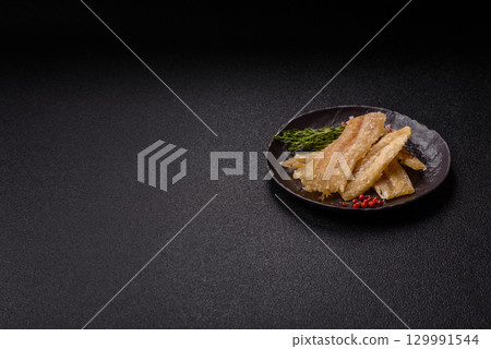 Dried salted fish, snacks or jerky, slices of white fish fillets 129991544