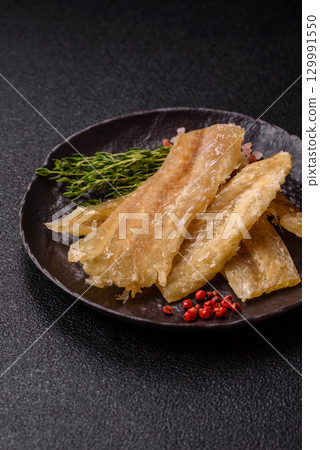Dried salted fish, snacks or jerky, slices of white fish fillets 129991550
