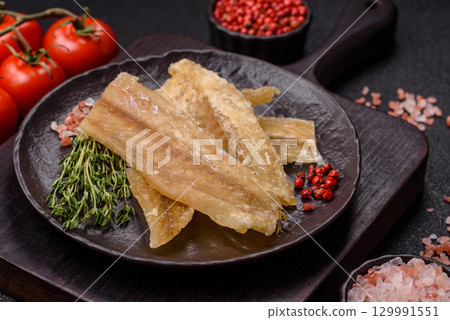 Dried salted fish, snacks or jerky, slices of white fish fillets 129991551