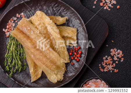 Dried salted fish, snacks or jerky, slices of white fish fillets 129991552