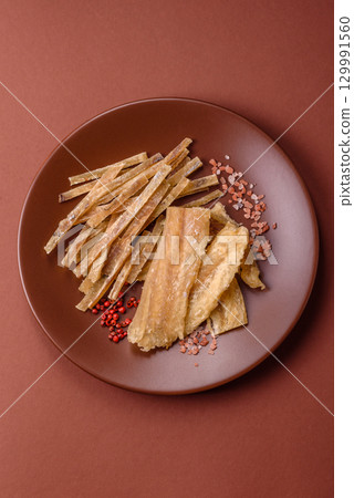 Dried salted fish, snacks or jerky, slices of white fish fillets 129991560