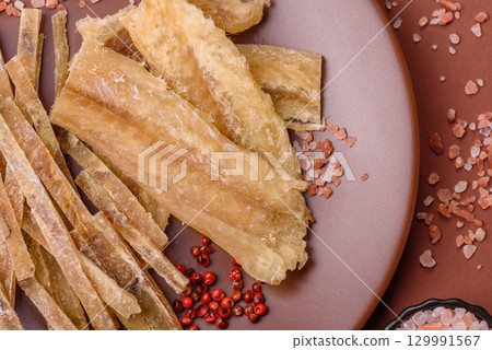 Dried salted fish, snacks or jerky, slices of white fish fillets 129991567