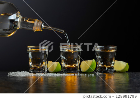Tequila with lime and salt on a stone table. Tequila with lime and salt on a stone table. 129991799