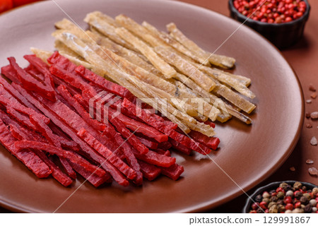 A set of jerky or snacks of chicken and fish with salt and spices A set of jerky or snacks of chicken and fish with salt and spices 129991867