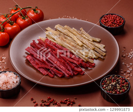 A set of jerky or snacks of chicken and fish with salt and spices 129991873
