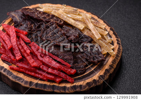 A set of jerky or snacks of beef, chicken and fish with salt and spices 129991908