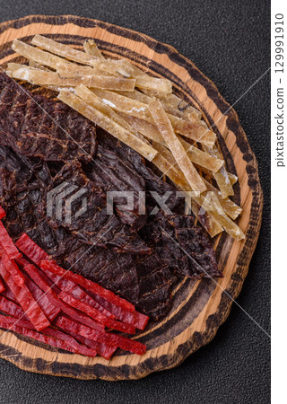 A set of jerky or snacks of beef, chicken and fish with salt and spices A set of jerky or snacks of beef, chicken and fish with salt and spices 129991910