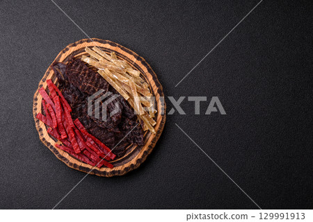 A set of jerky or snacks of beef, chicken and fish with salt and spices A set of jerky or snacks of beef, chicken and fish with salt and spices 129991913