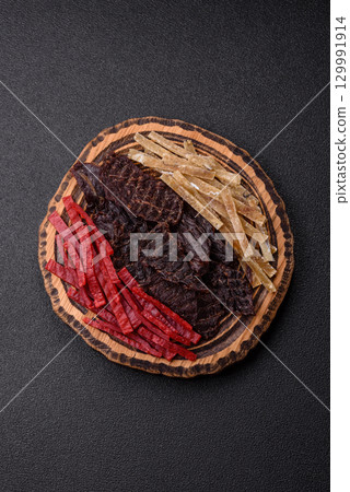 A set of jerky or snacks of beef, chicken and fish with salt and spices A set of jerky or snacks of beef, chicken and fish with salt and spices 129991914