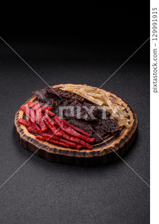 A set of jerky or snacks of beef, chicken and fish with salt and spices A set of jerky or snacks of beef, chicken and fish with salt and spices 129991915