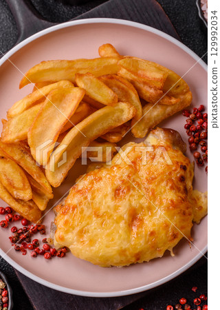Fried French fries with a piece of meat, lunch food. Prepared potatoes and meat 129992034