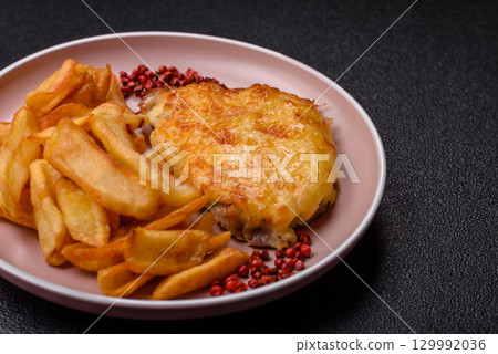 Fried French fries with a piece of meat, lunch food. Prepared potatoes and meat Fried French fries with a piece of meat, lunch food. Prepared potatoes and meat 129992036