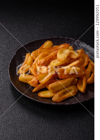 Fried crispy French fries with salt, spices, food for lunch Fried crispy French fries with salt, spices, food for lunch 129992051